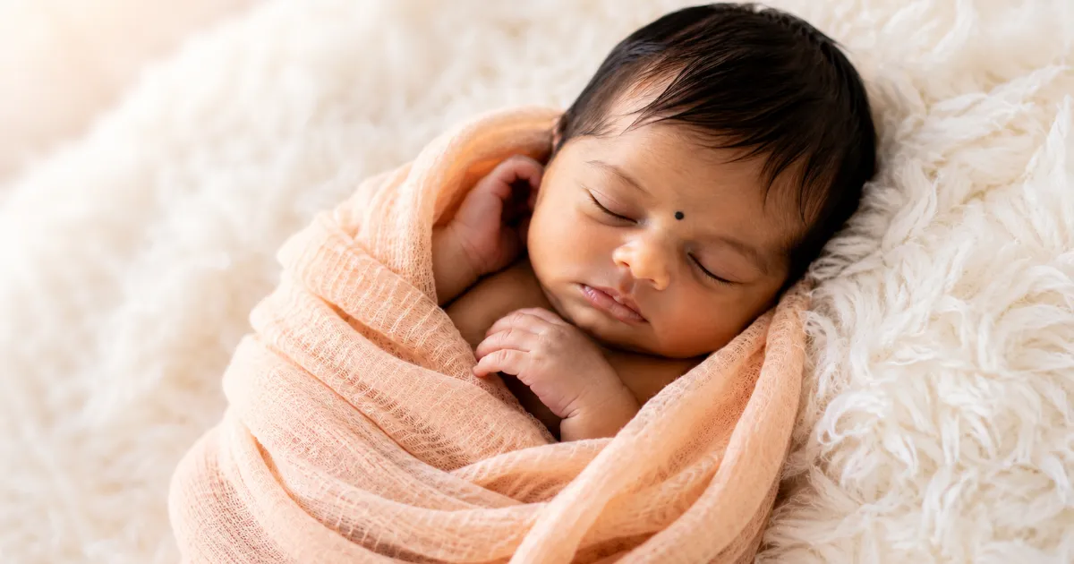 A cute newborn Indian baby wrapped in muslin cloth generated by saree AI prompts